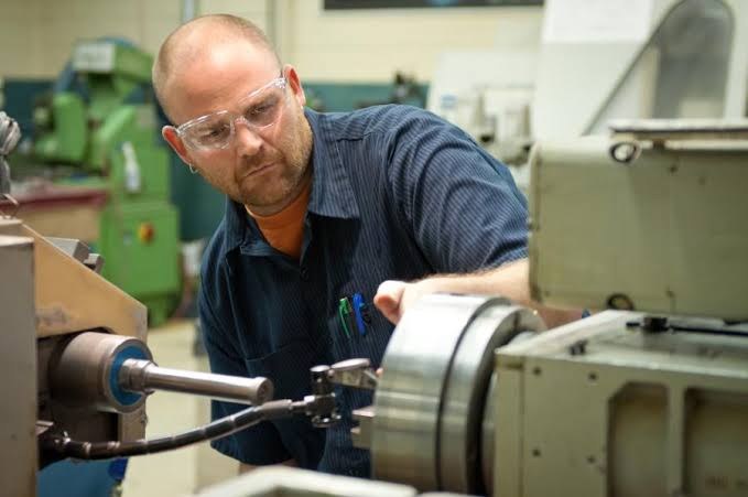 A technician checks a machine on the shop floor.